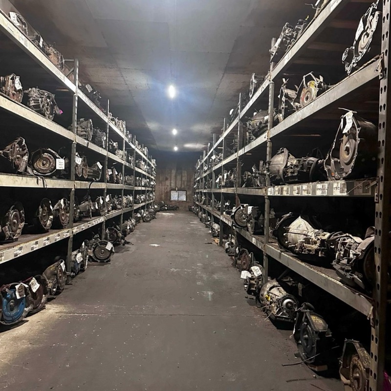Aisle of used transmissions on steel shelving at Villanueva Auto’s Salinas warehouse